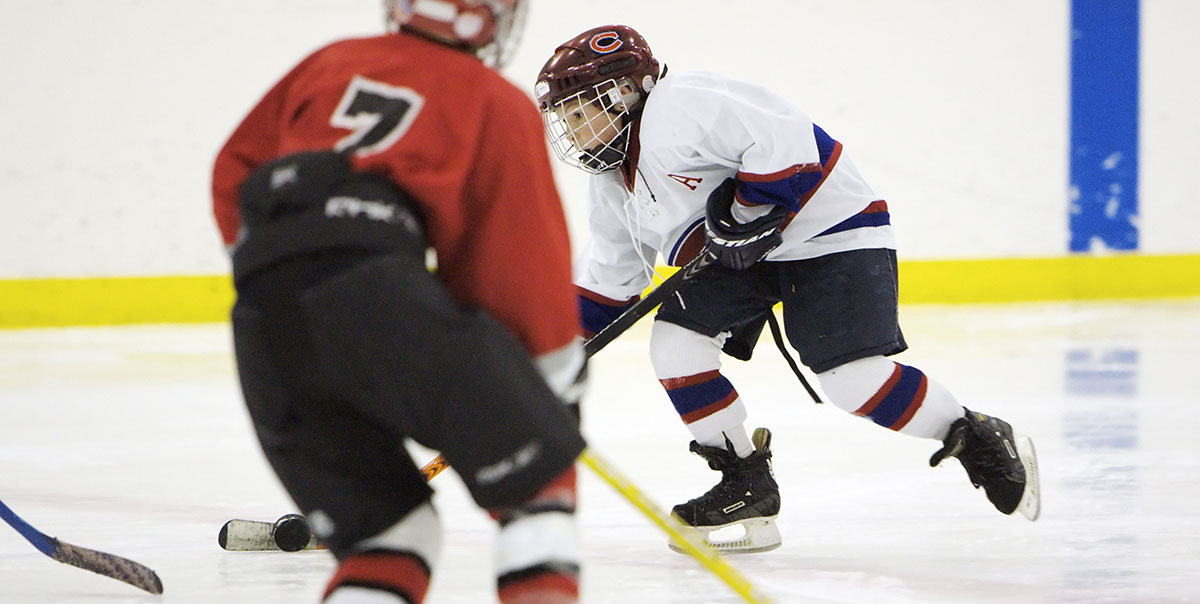 Youth hockey player carrying puck in small area game